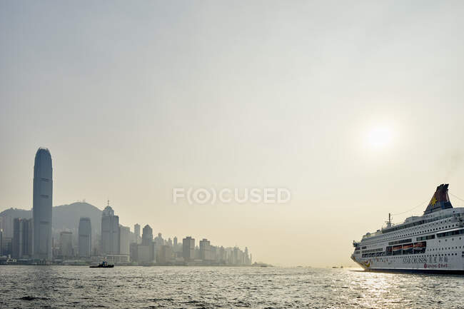 Crucero y rascacielos en frente del mar, Hong Kong, China - foto de stock