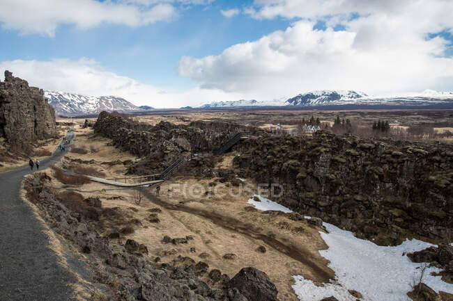 Vue surélevée du paysage accidenté et de la montagne recouverte de neige lointaine — Photo de stock