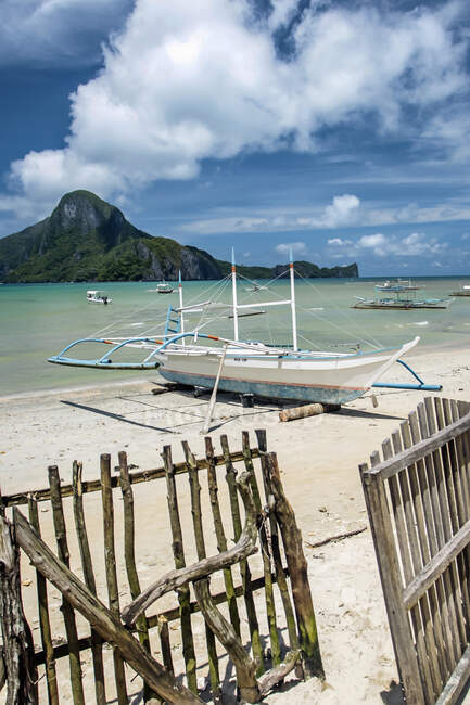 Valla de piquete y barco en la playa, El Nido, Isla Palawan, Filipinas - foto de stock