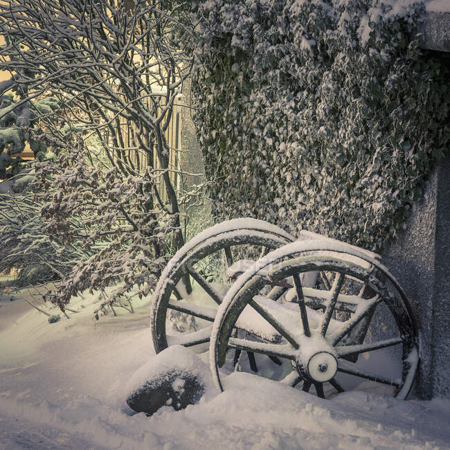 Snow covered bench and old wheels on winter morning, Hafnarfjord — Stock Photo