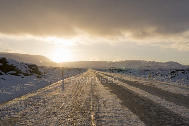 Sonnenbeleuchtete eisige Landstraße im Winter, Reykjanes, Südisland — Stockfoto