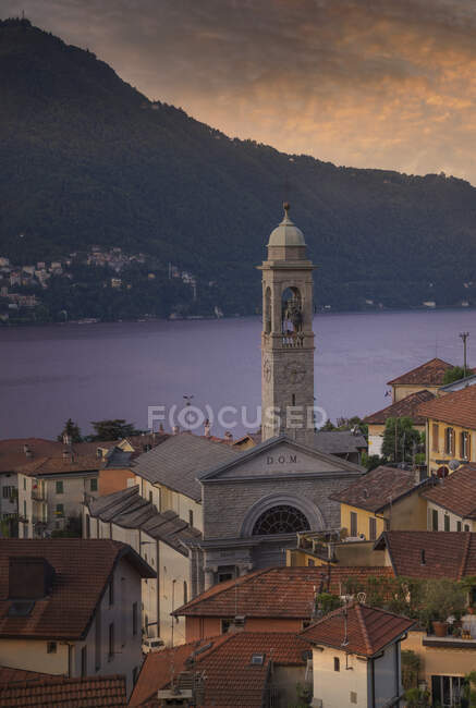 Salida del sol sobre el Lago de Como y pueblo frente al mar, Italia - foto de stock