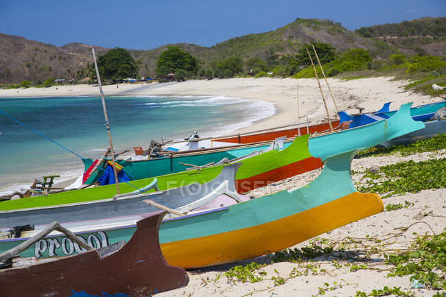 Coloridos barcos de pesca en la playa de Mawun, Pantai Mawun, Lombok, Indonesia - foto de stock
