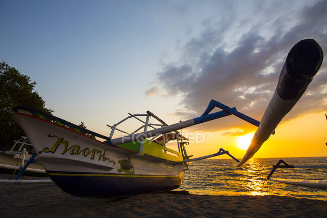 Barco de pesca silhueta ao pôr do sol na praia de Senggigi, Lombok, Indonésia — Fotografia de Stock