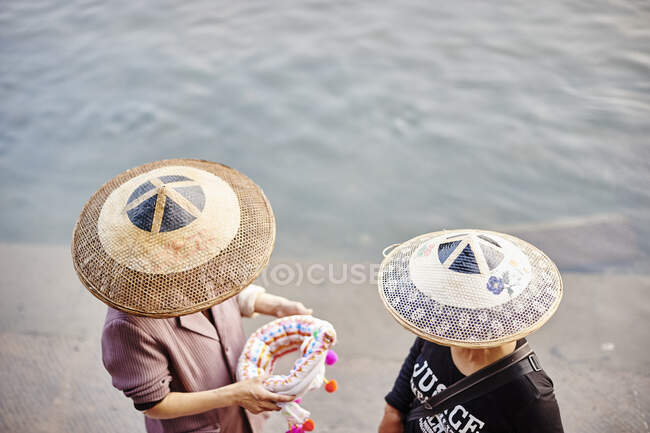 Vista elevada de la gente local con sombreros, Fenghuang, Hunan, Ch - foto de stock