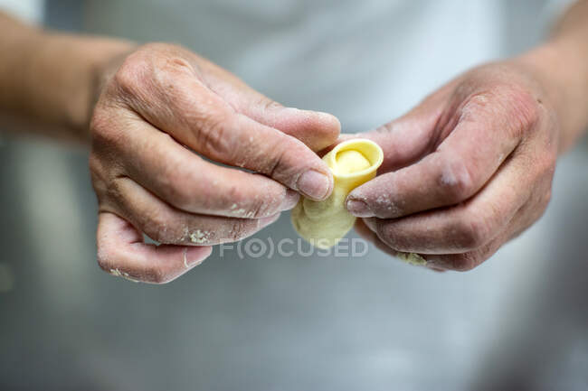 Primo piano delle mani dei pastai maschi che modellano la pasta, Cagliari, Sar — Foto stock