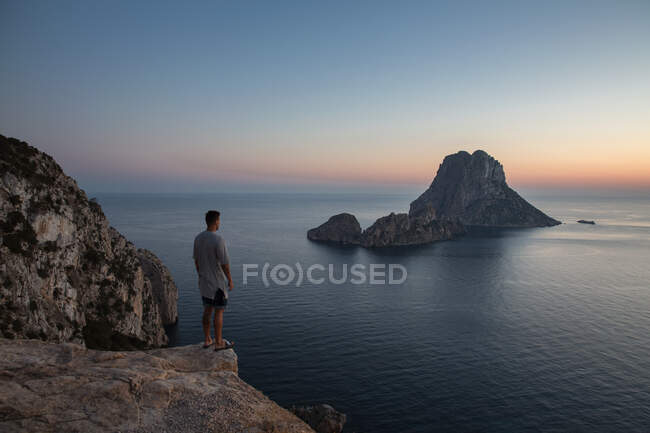 Jeune homme regardant coucher de soleil sur Es Vedra, Ibiza, Espagne — Photo de stock
