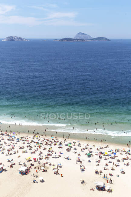 Туристи на пляжі, острови Кагаррас на відстані, Іпанема, Ріо - де - Жанейро — стокове фото