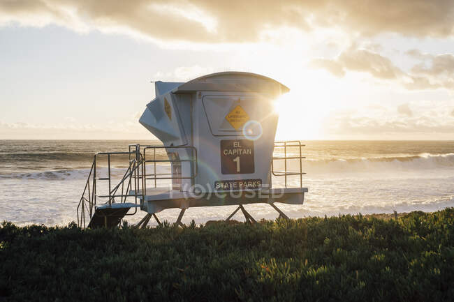 Torre de salva-vidas pelo oceano ao pôr-do-sol — Fotografia de Stock