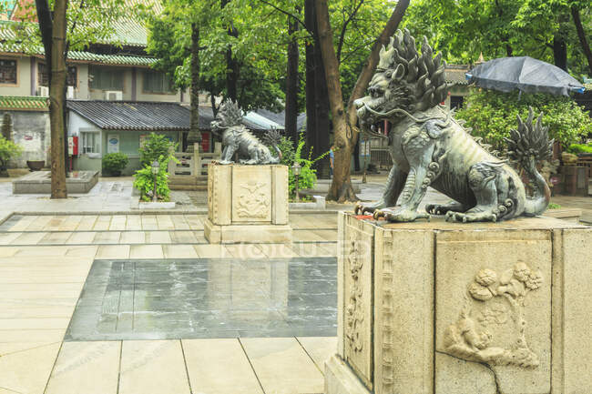 Вид сбоку на статуи льва на постах, храм предков Фошань — стоковое фото