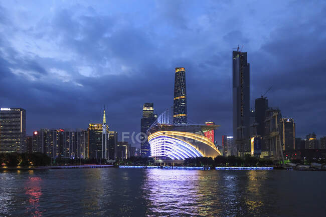 Riverfront olympic stadium and floating restaurant illuminated at night — Stock Photo