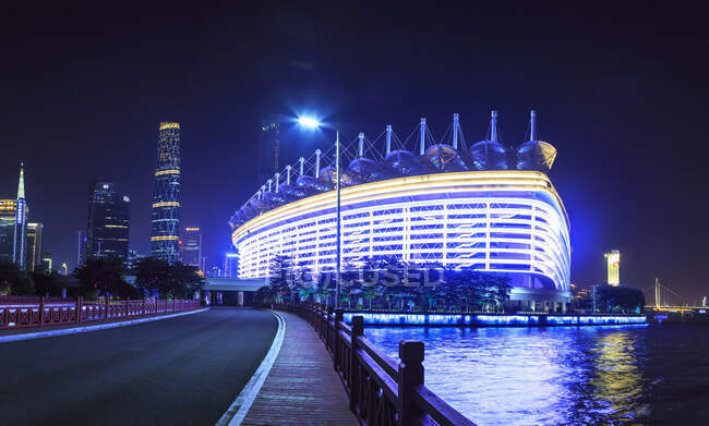 Олимпийский стадион на берегу реки, освещенный ночью, Гуанчжоу, Китай — стоковое фото