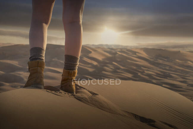 Pieds de femme sur une dune de sable géante dans le désert au coucher du soleil, bas se — Photo de stock