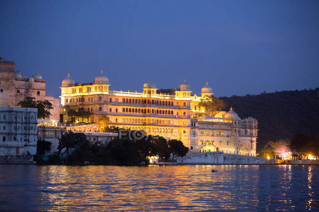 Floodlit City Palace on lake Pichola waterfront at dusk, Udaipur — Stock Photo
