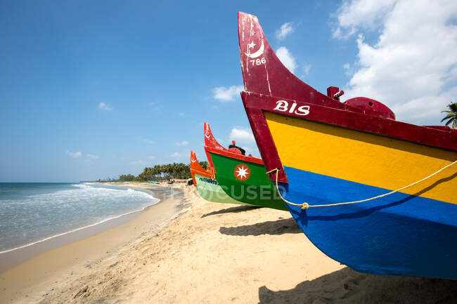 Fila de coloridos barcos de pesca en playa, Varkala, Kerala, India - foto de stock