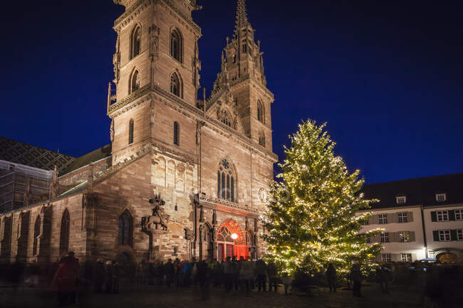 Crowds of people around illuminated Christmas tree by church, Ba — Stock Photo