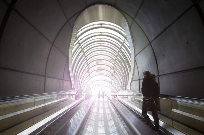 Vista trasera de la mujer subiendo escaleras de metro en túnel, Bilbao, - foto de stock