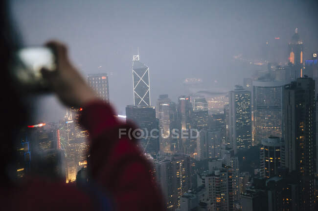 Über-die-Schulter-Ansicht von Touristen, die nachts Wolkenkratzer fotografieren — Stockfoto