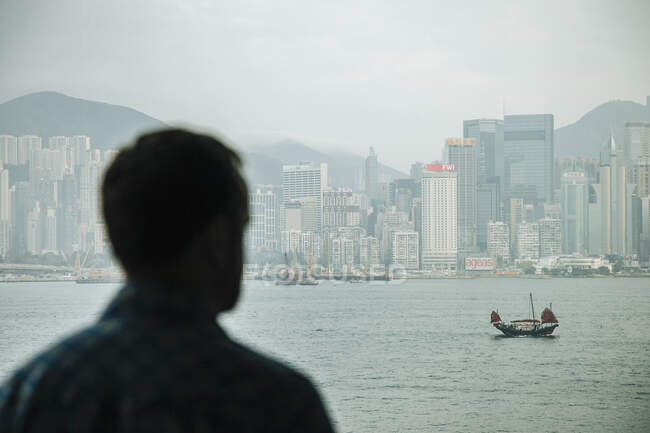 Sobre a vista do ombro do homem olhando para fora em tralha chinesa cruzando V — Fotografia de Stock
