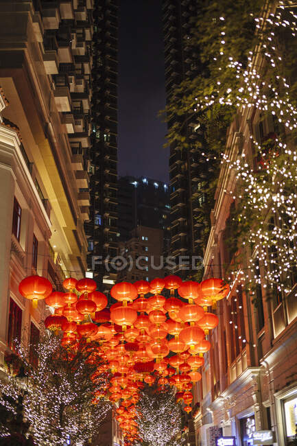 Lanternes chinoises rouges entre les gratte-ciel la nuit, Hong Kong, Chine — Photo de stock