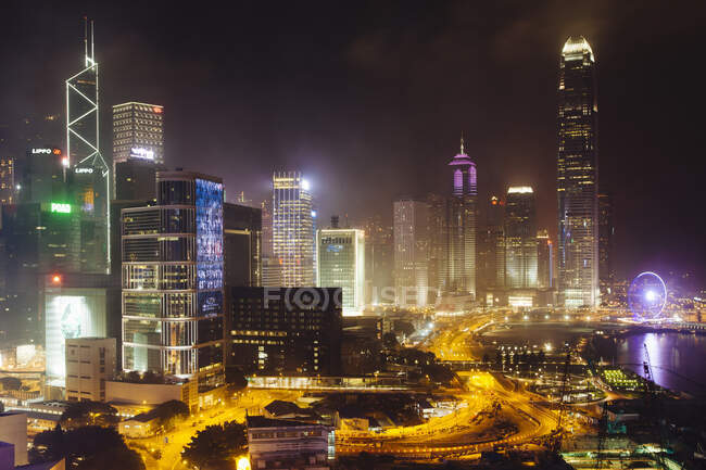 Высокоугольный городской пейзаж с шоссе и небоскребами ночью — стоковое фото