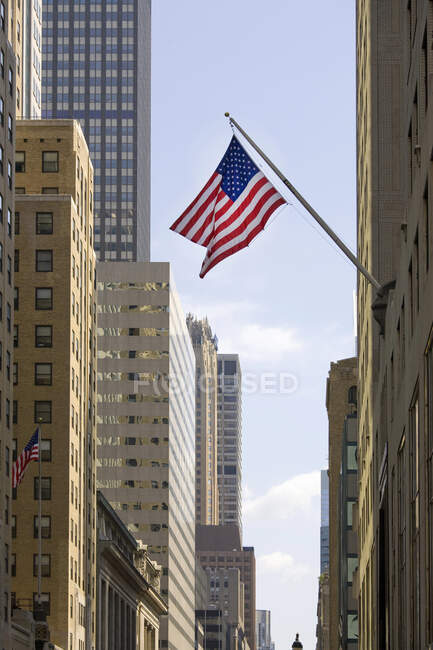 Skyscrapers with stars and stripes flag flying, New York City — Stock Photo