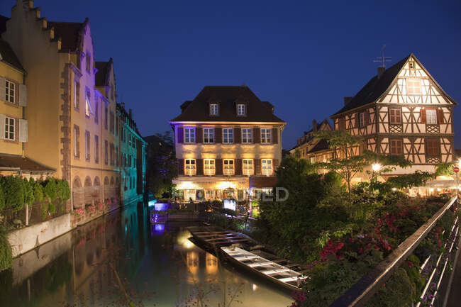 Barcos en el canal por la noche, rodeado de casas medievales, Colmar - foto de stock