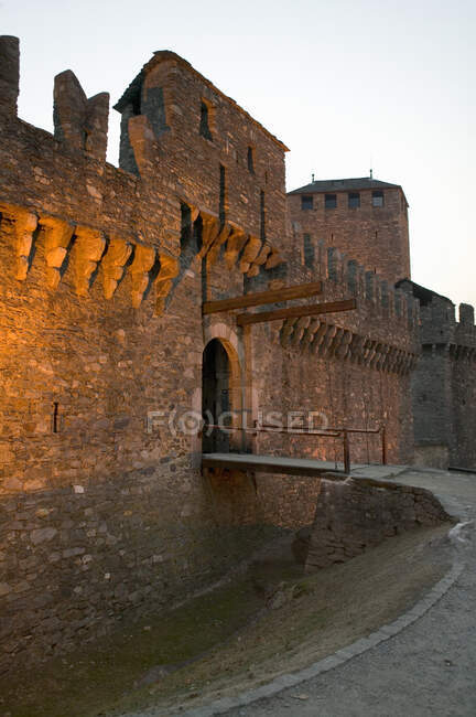 Entrée et pont-levis du mur de Bellinzona illuminés la nuit — Photo de stock
