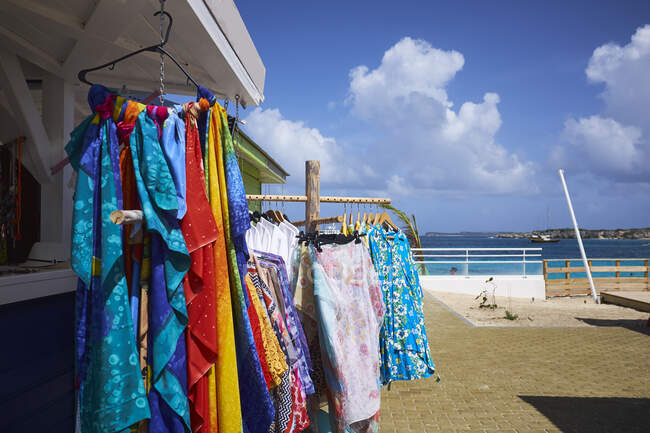 Shop clothes rail with sarongs and t-shirts at coast, Saint Mart — Stock Photo