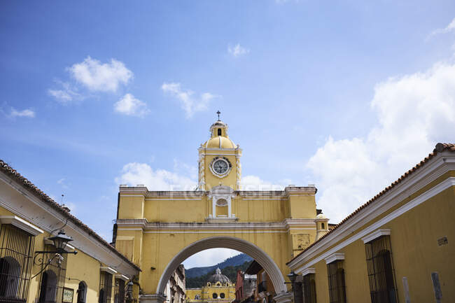 View of historic yellow clock tower over Santa Catalina Arch, An — Stock Photo