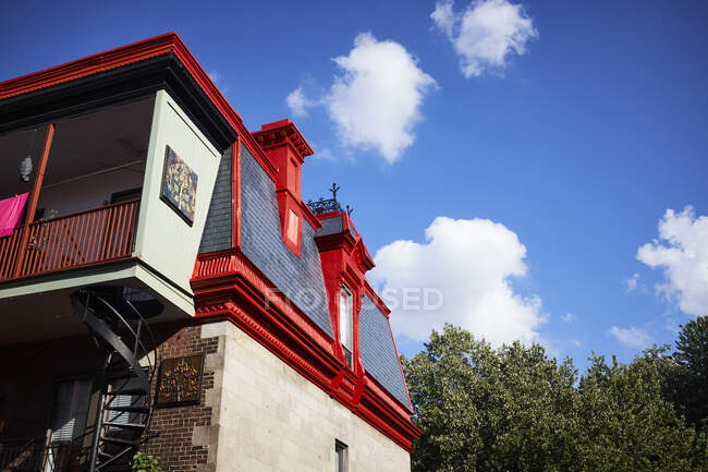 Casa tradicional con detalles pintados de rojo y balcón - foto de stock