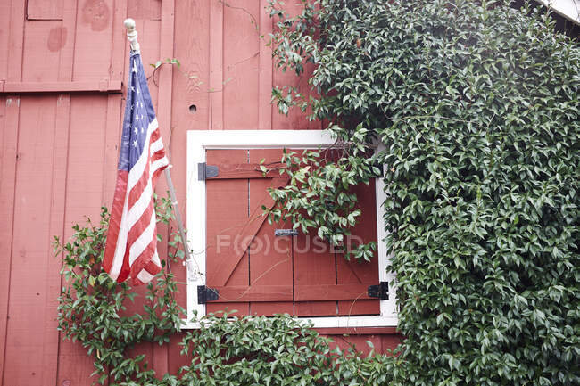 Granero rojo tradicional y bandera estadounidense, California, EE.UU. - foto de stock