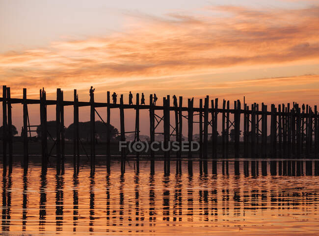 Silhouette di persone sul ponte U Bein al tramonto, Mandalay, Manda — Foto stock