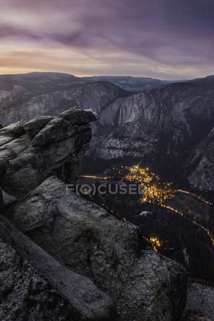 Mountains and city lights in valley at dusk from Glacier Point, — Stock Photo