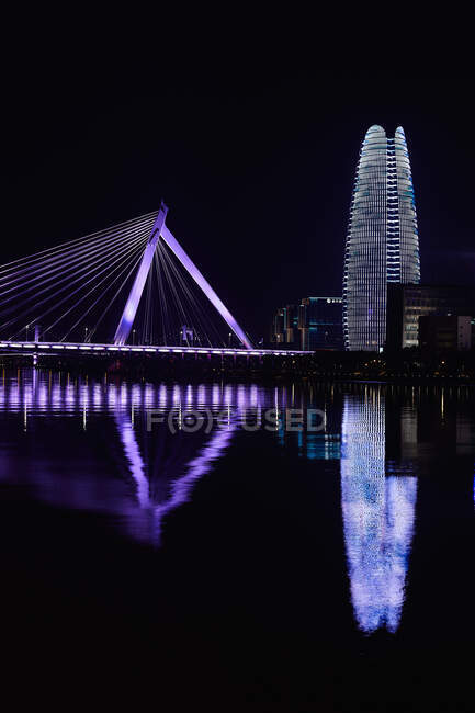 Flutlichtbrücke und Wolkenkratzer über dem Fluss bei Nacht, Ningbo, Zhej — Stockfoto