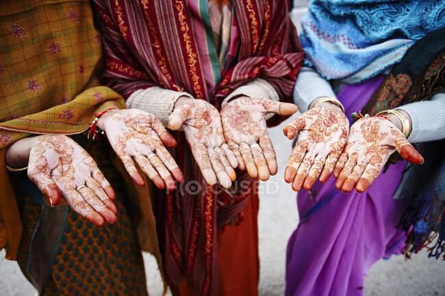 Tiro cortado de três mulheres locais com henna mehndi na palma da mão — Fotografia de Stock