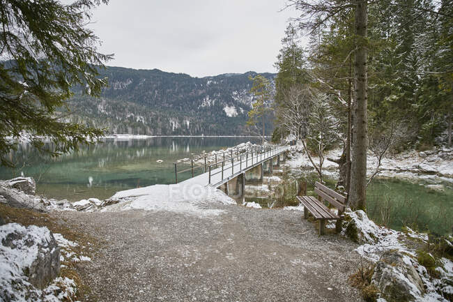 Verschneite Berglandschaft mit Fußgängerbrücke über den Eibsee, Zugsp — Stockfoto
