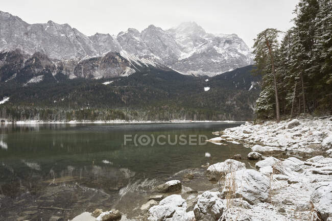Lago Eibsee y montañas en la nieve, Zugspitze, Baviera, Alemania - foto de stock