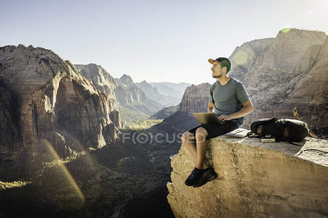 Человек путешествует Ангелы посадки след, сидя на скале, с помощью ноутбука, — стоковое фото