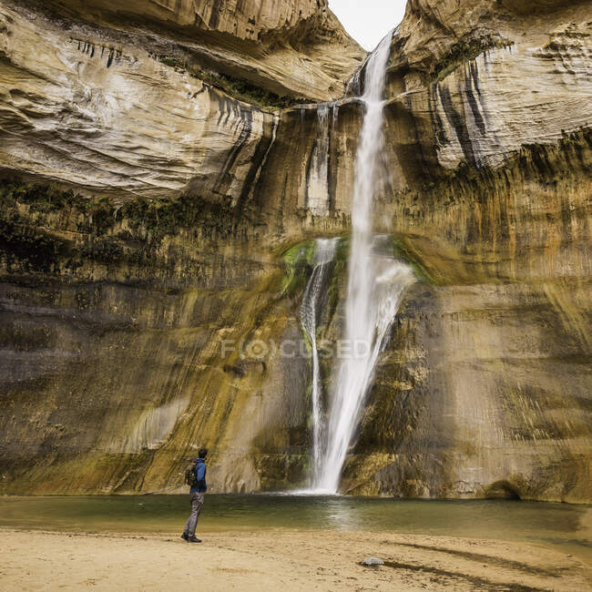 Homem caminhando perto de cachoeira, Calf Creek Falls perto de Escalante, Utah — Fotografia de Stock