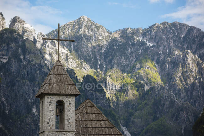 Campanario de la iglesia del pueblo y Montañas Malditas, Theth, Tirana, - foto de stock