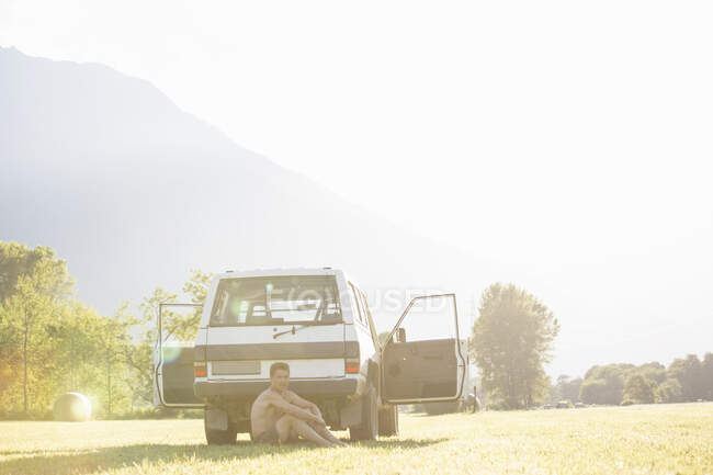 Man relaxing behind vehicle in park — Stock Photo
