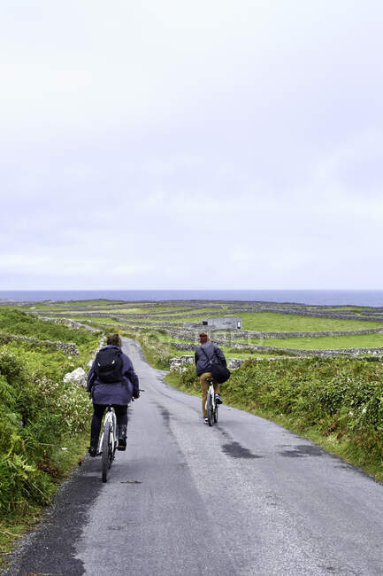 Велогонщики на шоссе, Инишмор, Ирландия — стоковое фото