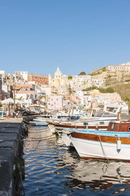 Edificios y embarcaciones portuarias en la isla de Procida, Campania, Italia - foto de stock