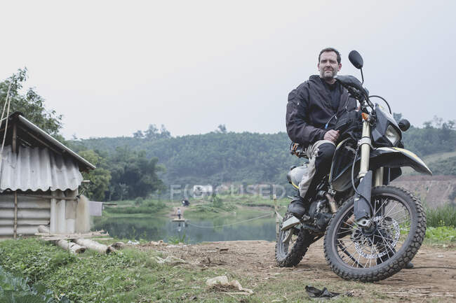 Man on motorcycle in rural landscape, Vietnam — Stock Photo