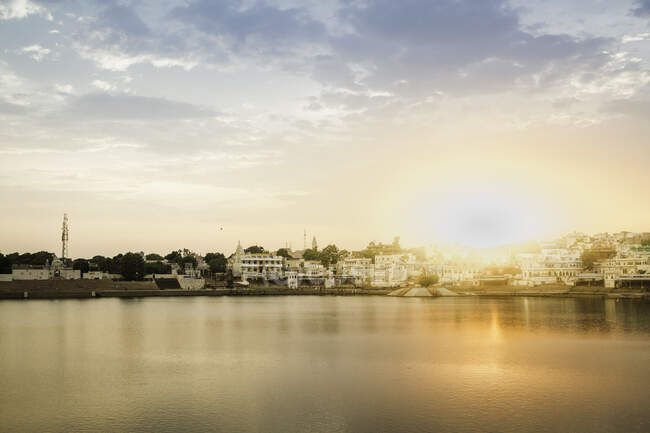 Scenic view of buildings in sunlight across water, Pushkar, Raja — Stock Photo