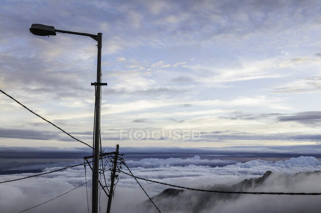 Lamppost y cables telefónicos sobre las nubes, Mussoorie, Uttara - foto de stock