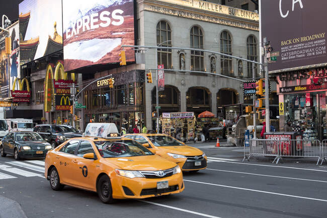 Cabinas amarillas y fachadas de tiendas, Times Square, Nueva York, EE.UU. - foto de stock