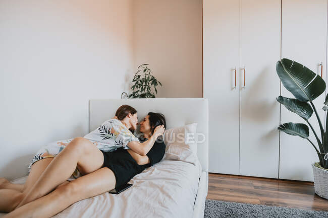 Dos mujeres lesbianas besándose en la habitación - foto de stock