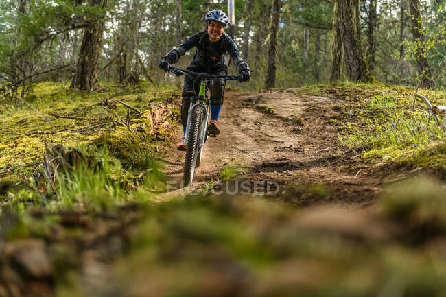 Bicicleta de montaña mujer en un bosque en las montañas canadienses - foto de stock